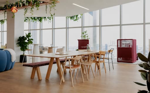 A room with a long table and chairs with a view of the city.