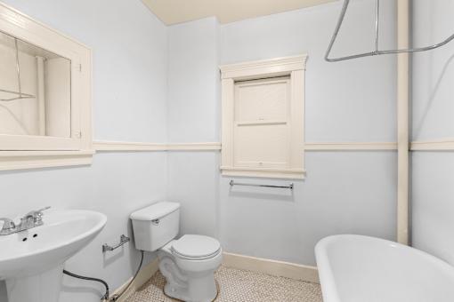 A white toilet sits next to a sink in a bathroom.