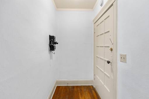 A white door with a keyhole and a black security system.