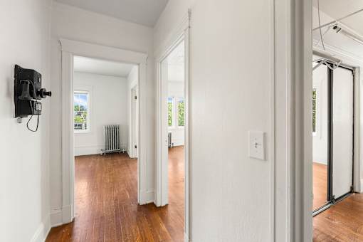 A hallway with a black electrical box on the wall.