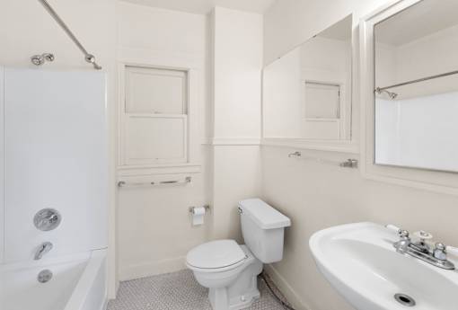 A white bathroom with a toilet, sink, and bathtub.