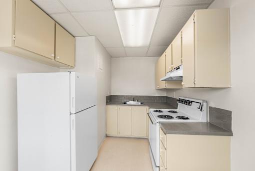 A kitchen with white appliances and beige cabinets.