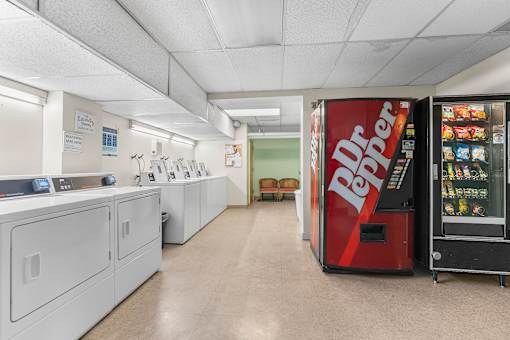 A red Dr Pepper vending machine is on the right side of a laundromat.