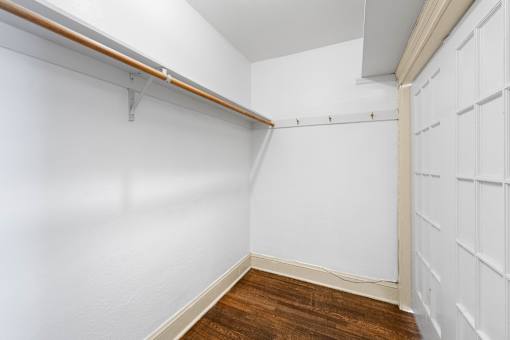 A white wall with a brown wooden floor and a white door.
