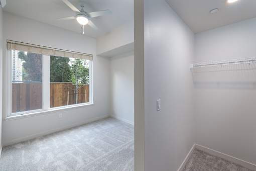 A room with a window and a fan on the ceiling.