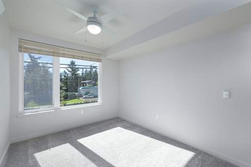 A room with a window and a ceiling fan.