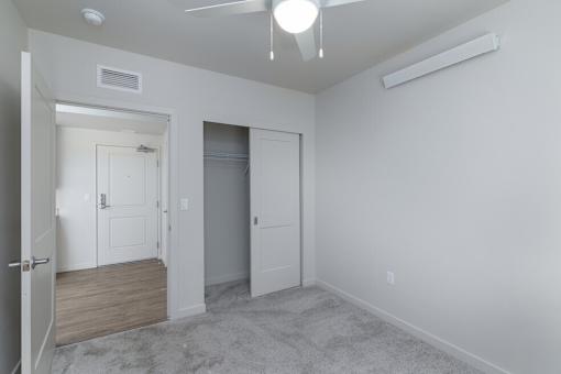 A room with a white ceiling, a white door, and a white wall.