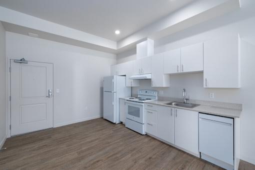 A kitchen with white cabinets and appliances.