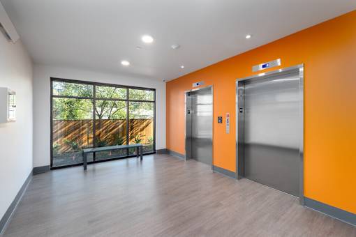 A room with orange walls and a wooden floor.