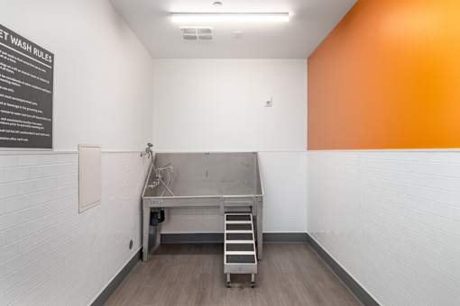 A clean and empty pet wash room with a sign on the wall.