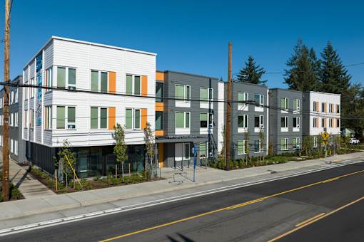 A row of modern townhouses with a clear blue sky above.