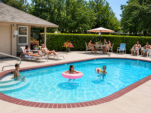 People are enjoying their time in the pool with inflatable rings.