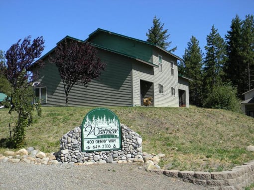 a green and white sign in front of a house
