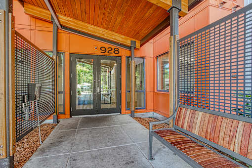 A building with a wooden roof and a bench in front of it.