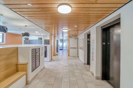 A long hallway with a wooden ceiling and tile flooring.