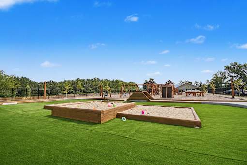 A playground with a sandbox and a slide.