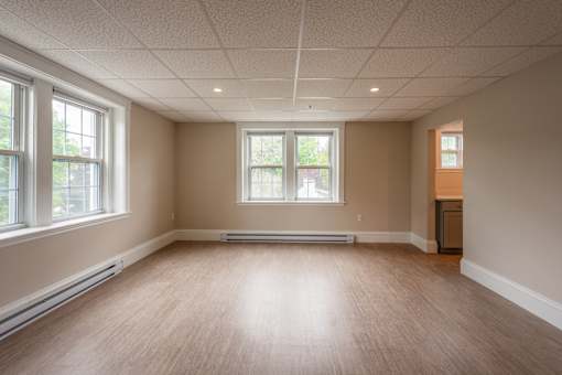 A room with wooden floors and two windows.