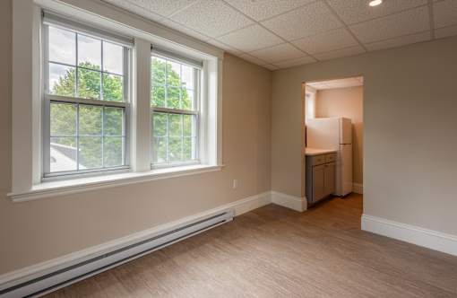 A room with a window and a door on the right side.