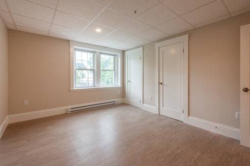 A room with a window, a door, and a radiator.