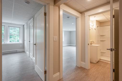 A white bathroom with a sink and a window.