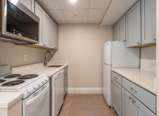 A kitchen with white appliances and cabinets.