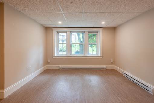 A room with a window and wooden flooring.