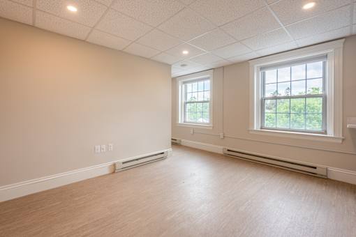 A room with a window and a wall-mounted air conditioner.