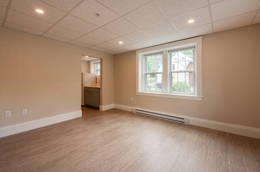 A room with a window and a door on the left side.