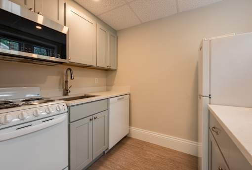 A kitchen with white appliances and cabinets.