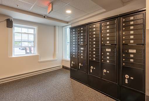 A room with a large number of mailboxes on the wall.