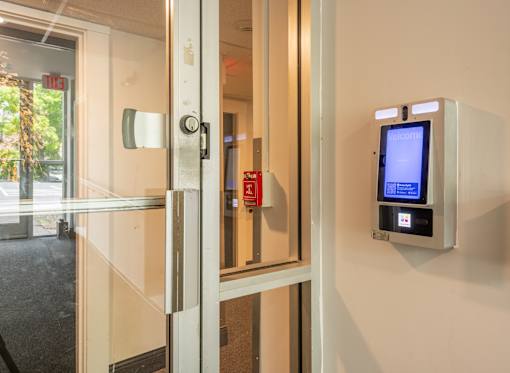 A glass door with a red emergency sign on it.