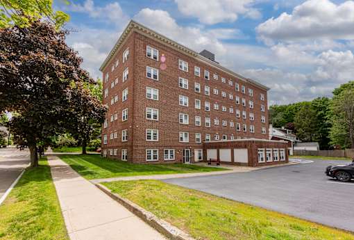 A red brick building with a green lawn in front.