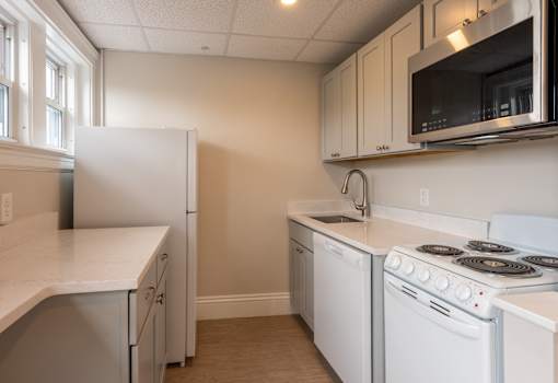 A kitchen with white appliances and a white refrigerator.