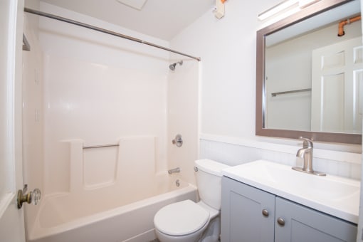 a bathroom with a white bathtub and a white toilet next to a white sink with a