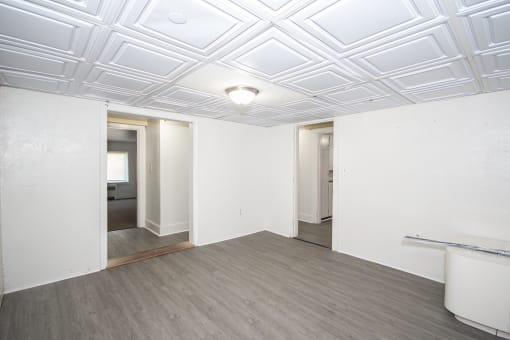 a bedroom with white walls and a coffered ceiling