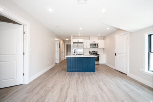 a kitchen with white cabinets and a blue island