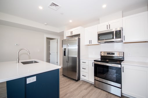 a kitchen with white cabinets and a blue island