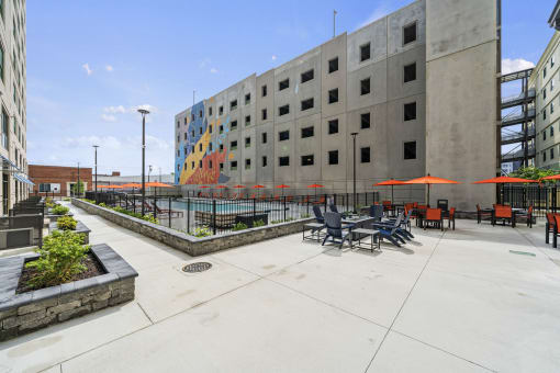 a courtyard with tables and chairs and a large building in the background  at The Icon, Richmond, VA, 23230