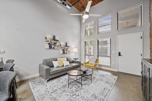 a living room with a gray couch and a yellow chair