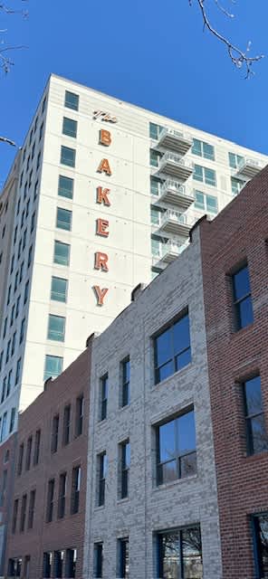 A tall white building with the word Bakery on it.