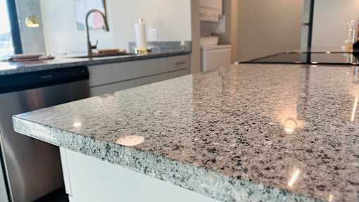 A granite countertop with a stainless steel dishwasher in the background.