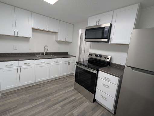 A kitchen with white cabinets and a black oven.