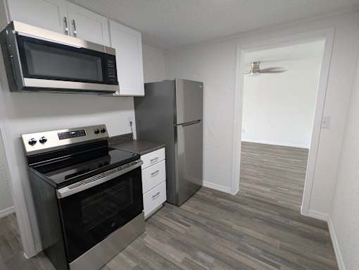 A kitchen with a stove, oven, microwave, and refrigerator.