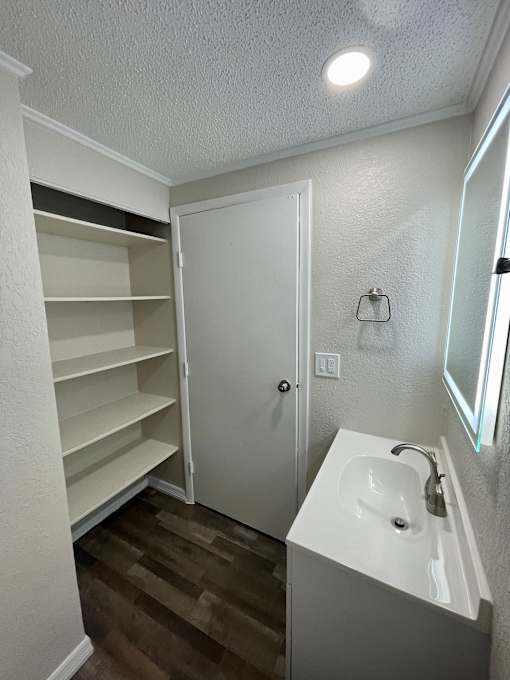 A small white bathroom with a sink and a mirror.
