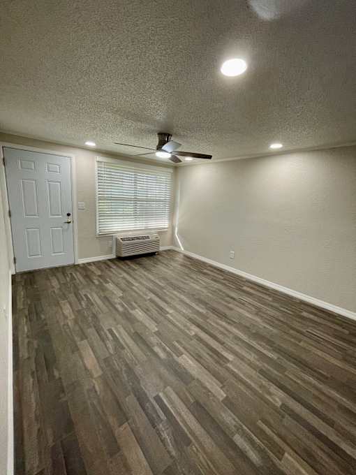 A room with a white door and a ceiling fan.