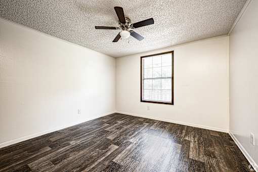 A room with a ceiling fan and a window.