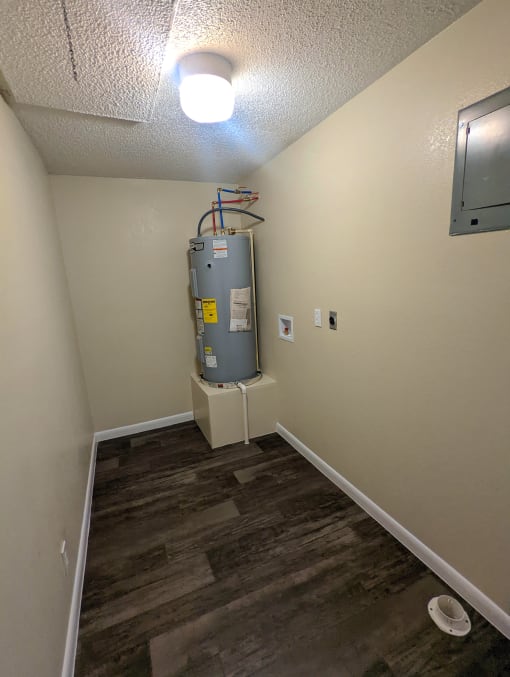 a room with a water heater in the corner
