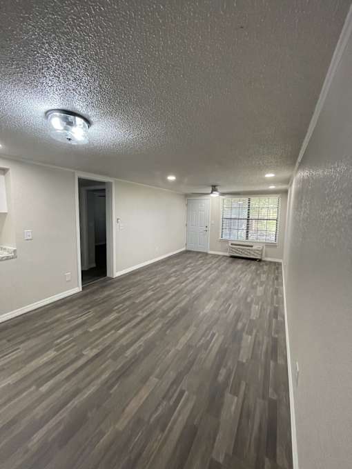 A room with a window and a wall with a wood panel design.