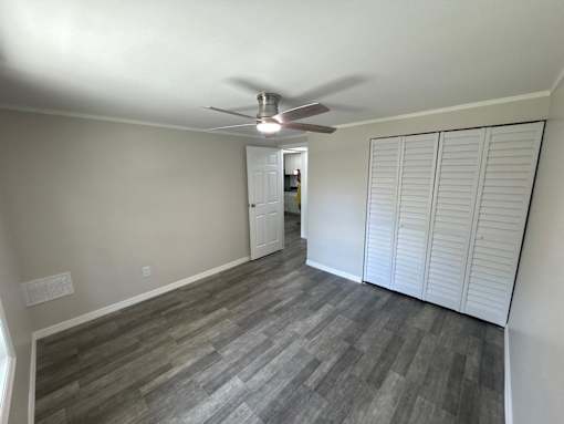 A room with a ceiling fan and a door.