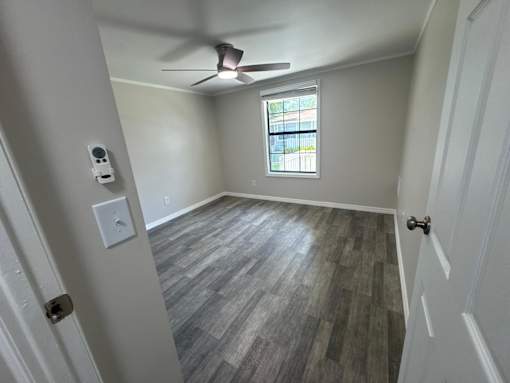 A room with a ceiling fan and a window.